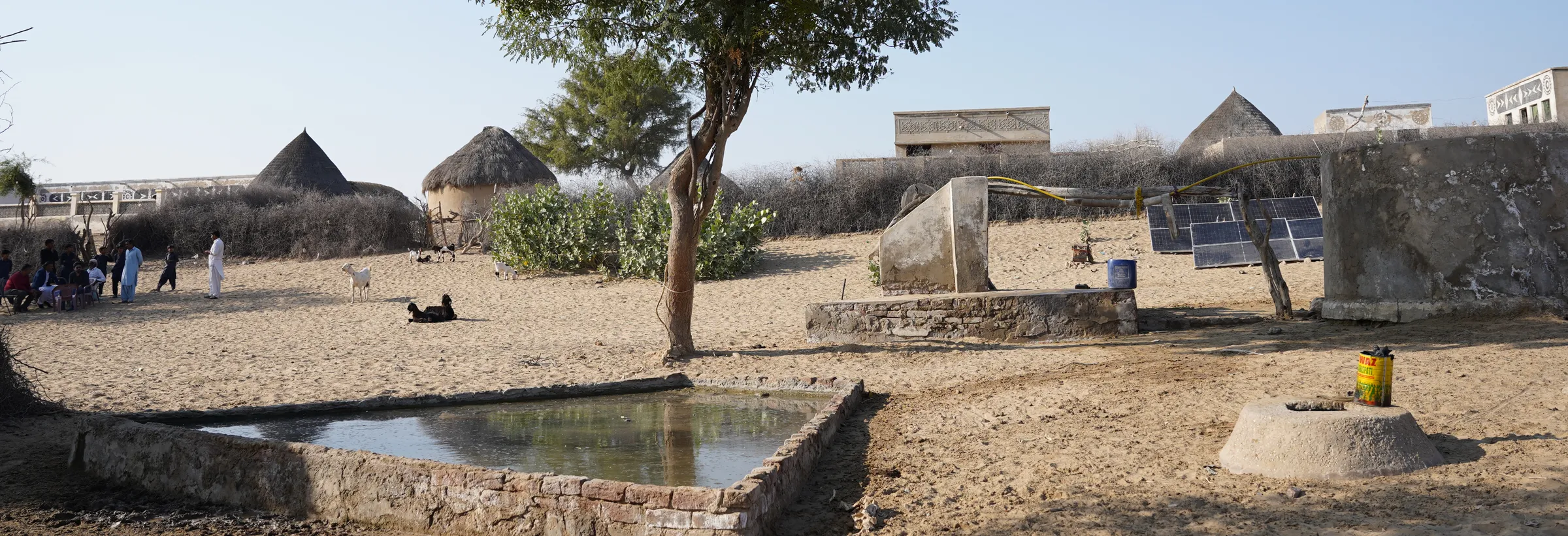 A village in Thar with a walled water tank, solar panels and thatched houses