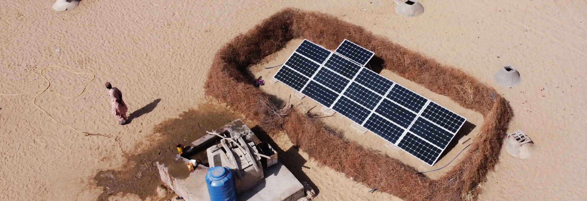 A solar array inside a thorn-fence enclosure on the Thar sand, seen from above